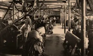 Arbeiter in einer Fabrik, die zeigt, wie funktioniert eine dampfmaschine, mit großen Rädern und Lederwaren.