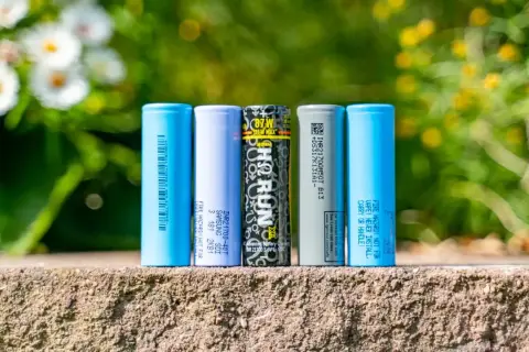 Fünf zylindrische Batterien, darunter Samsung und LG, stehen nebeneinander. Sie zeigen, was eine Batterie ist: eine Energiequelle.