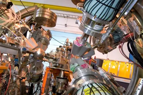 Komplexe Apparatur zur Erforschung des Astat-Elements, mit vielen Rohren, Kabeln und Metallteilen.
