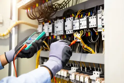 Elektriker misst die elektromotorische Kraft in einem Schaltschrank.