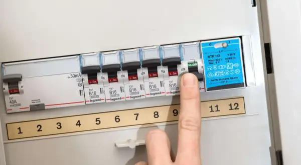 Finger schaltet Sicherung aus. So kann man eine defekte Sicherung erkennen.