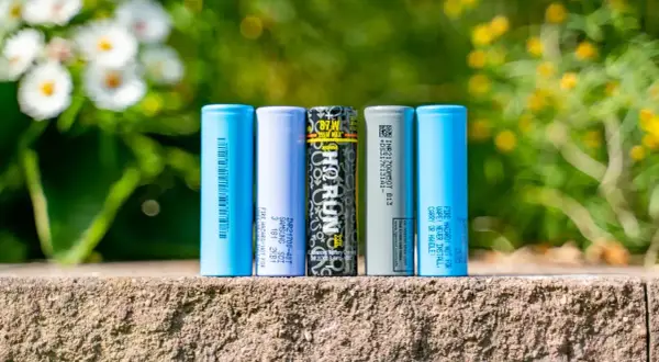 Fünf zylindrische Batterien, darunter Samsung und LG, stehen nebeneinander. Sie zeigen, was eine Batterie ist: eine Energiequelle.