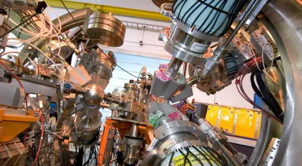 Komplexe Apparatur zur Erforschung des Astat-Elements, mit vielen Rohren, Kabeln und Metallteilen.