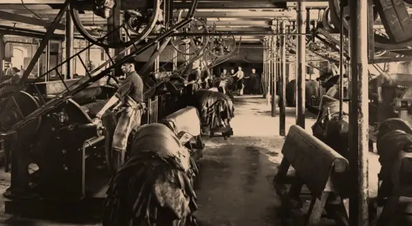 Arbeiter in einer Fabrik, die zeigt, wie funktioniert eine dampfmaschine, mit großen Rädern und Lederwaren.