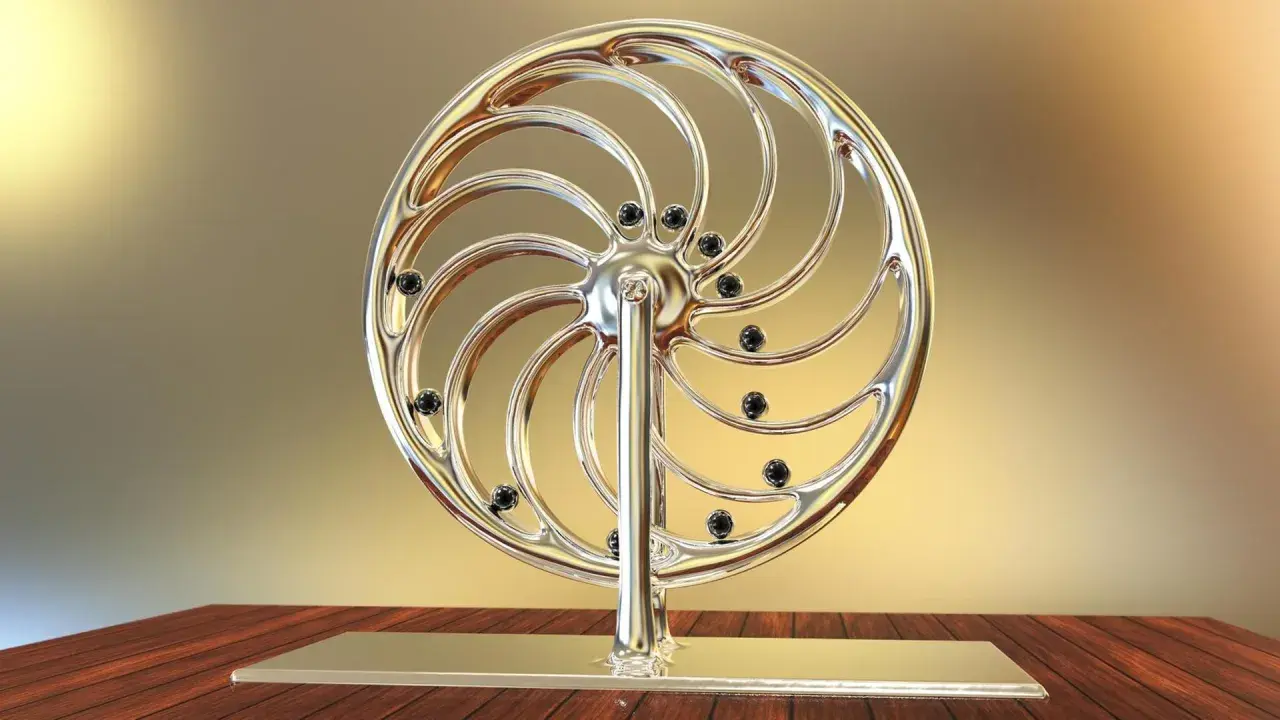 Glänzendes Rad mit schwarzen Kugeln, das an ein Perpetuum mobile erinnert, steht auf einem Holztisch.