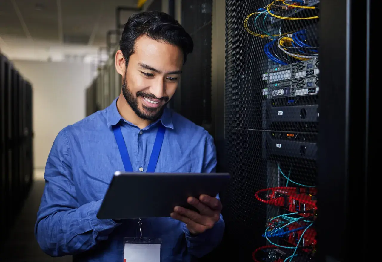 Ein Mann mit Tablet in einem Serverraum, der die **Verantwortung für Datenschutz im Unternehmen** wahrnimmt.