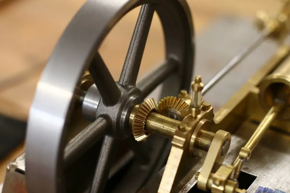 Detailaufnahme einer Modell-Dampfmaschine. Zahnräder und Kolbenstange zeigen, wie funktioniert eine dampfmaschine.
