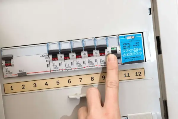 Finger schaltet Sicherung aus. So kann man eine defekte Sicherung erkennen.
