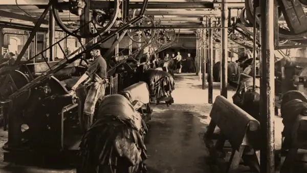 Arbeiter in einer Fabrik, die zeigt, wie funktioniert eine dampfmaschine, mit großen Rädern und Lederwaren.